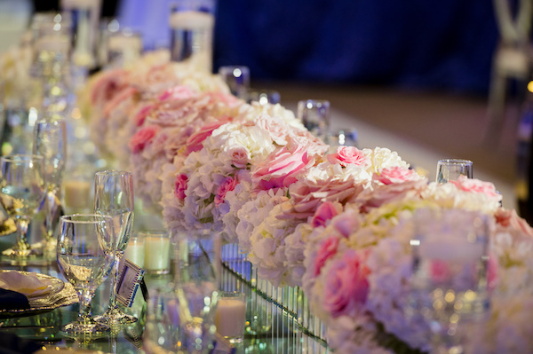 lush pink and white floral pieces on a long mirrored table