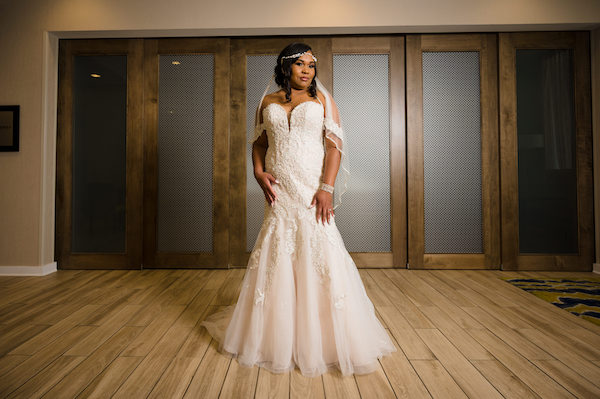 bride wearing an elegant lace and tulle wedding gown with a blush tone