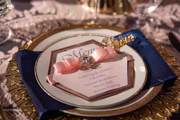 gold place setting with navy blue napkin at a Sophisticated North Charleston 