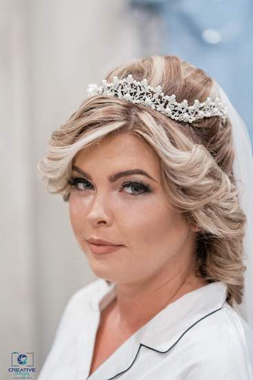 bride getting ready for her wedding day wearing a shimmering tiara